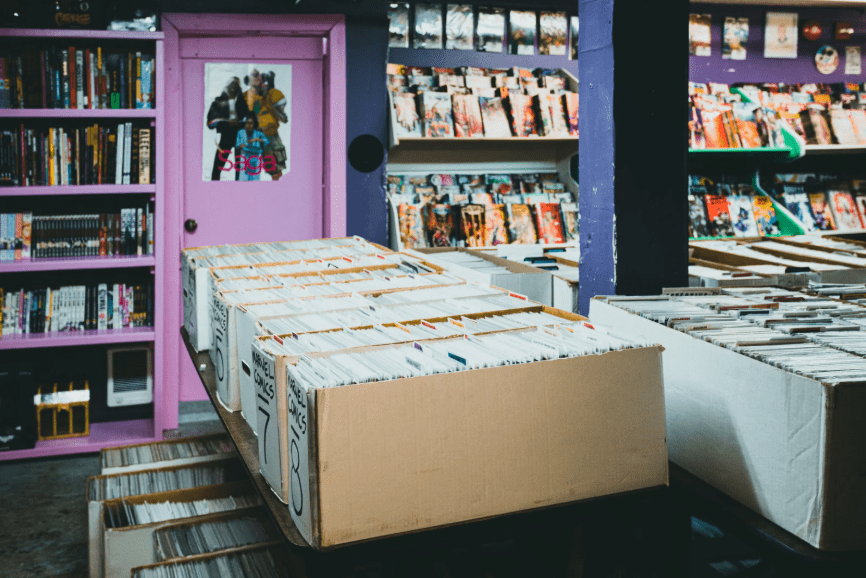 Una tienda de cómics y varias cajas de cómics en primer plano.