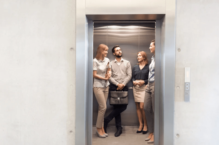 Un ascensor con cuatro personas vestidas formalmente.