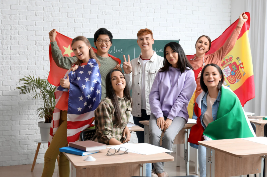 Un grupo de jóvenes con banderas de varios países cubriendo a algunos de ellos.