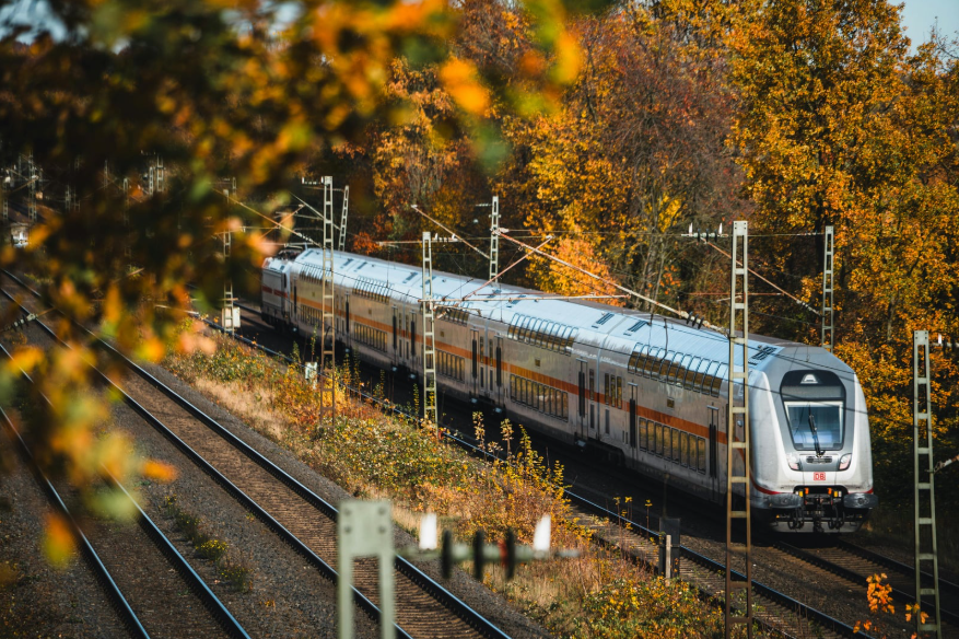Un tren cruzando un paisaje otoñal.