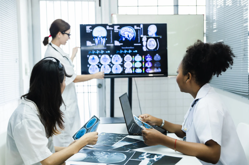 Tres médicos estudiando unas radiografías en un entorno hospitalario.