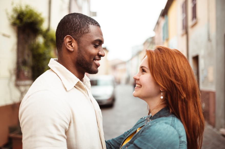 Dos jóvenes mirándose a los ojos con una sonrisa.